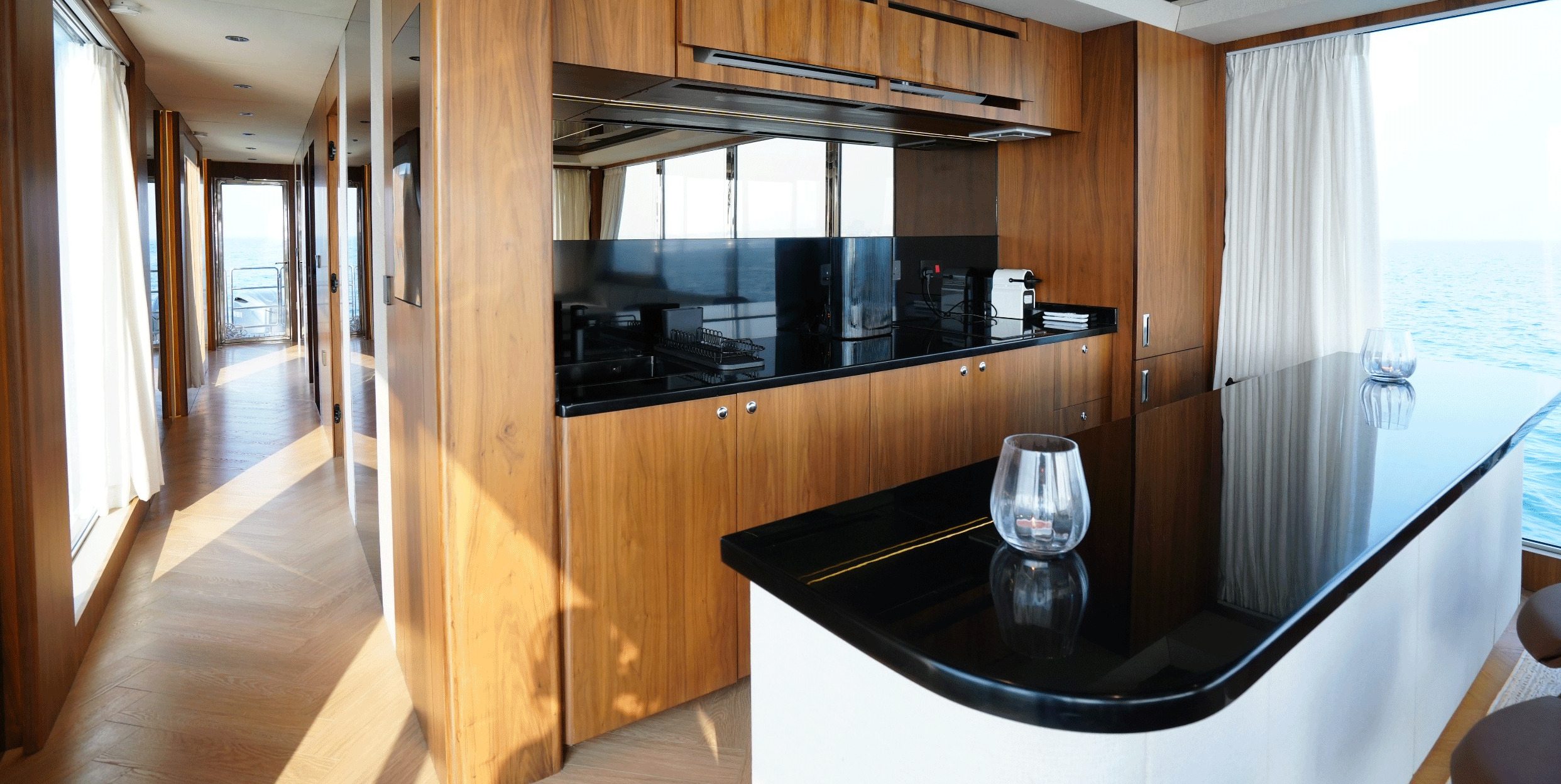 RISE 60 galley with timber joinery, black countertops and sea views